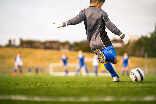 Kind spielt Fußball auf Bolzplatz
