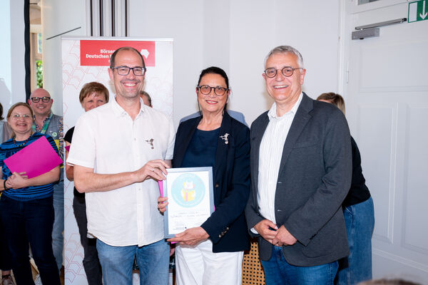 Sven Puchelt (von links) und Barbara Casper freuen sich zusammen mit Staatssekretär Arne Braun über die Auszeichnung „LeseEule“ in Gold. Foto: Sandra Wolf