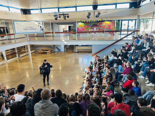 Buntes Bild und strahlende Gesichter: Die Straßenfest-Aktion des Remchinger Künstlers Sebastian Bauer (vorne) wirkt nun in der Bergschule Singen nach. Foto: Jochen Gottschalk / Bergschule Singen
