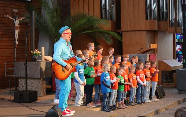 Mit seinem Programm „Knallvergnügt“ kam Musiker Daniel Kallauch in die Wilferdinger Christuskirche. Auch der Kinderchor „Lighthouse Kids“ durfte mit auf die Bühne. Foto: Zachmann 